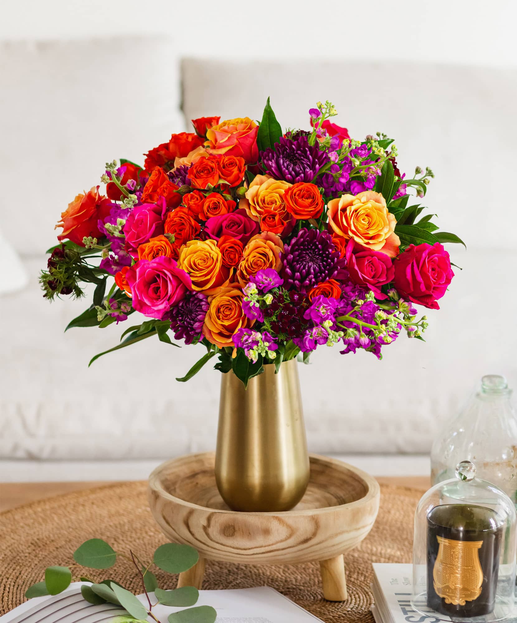 Vibrant floral arrangement featuring roses and purple blooms in a chic gold vase.