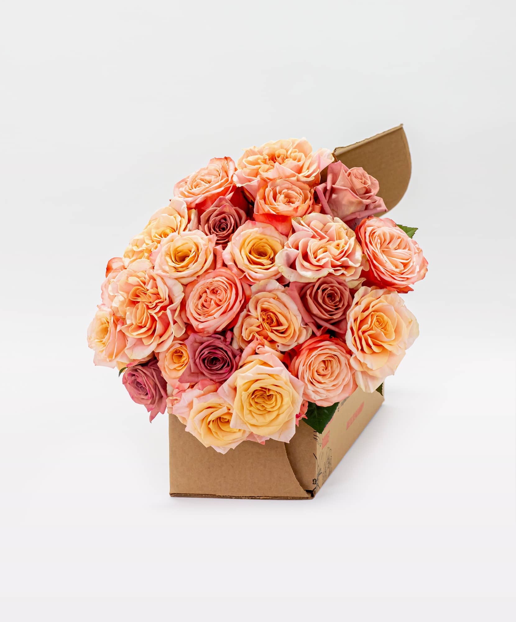 Vibrant bouquet of peach and pink roses beautifully arranged in a stylish box.