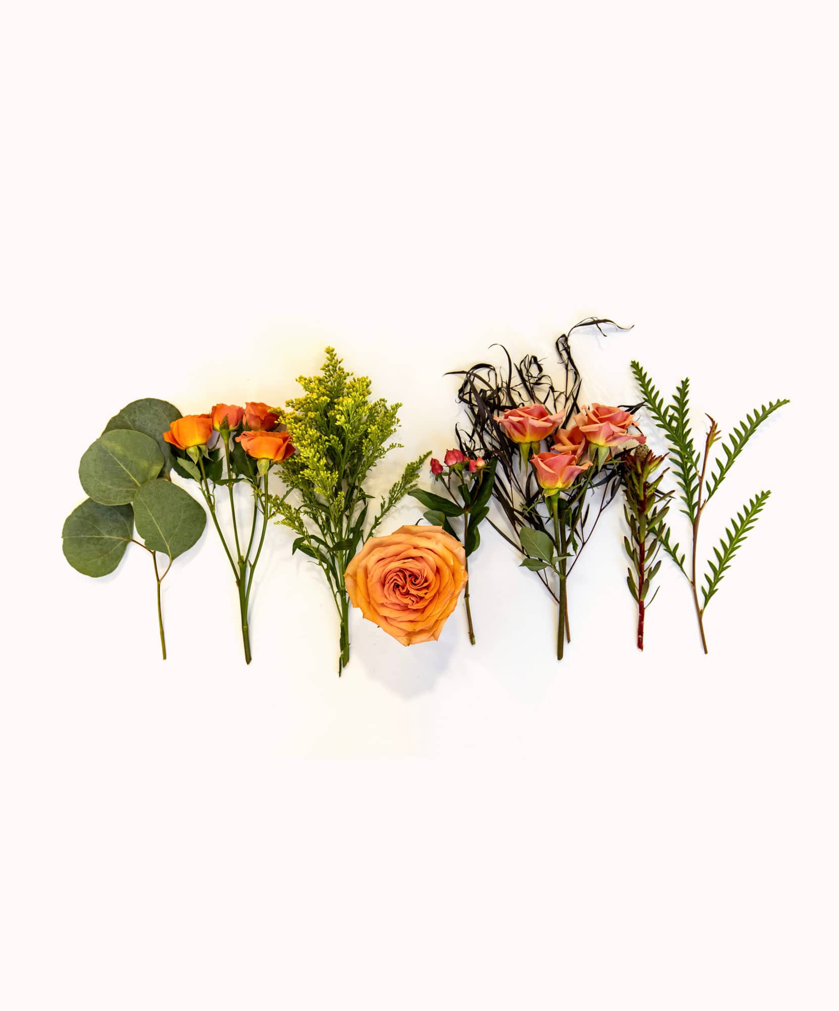 A beautiful arrangement of orange roses and greenery on a light background, ideal for decor.